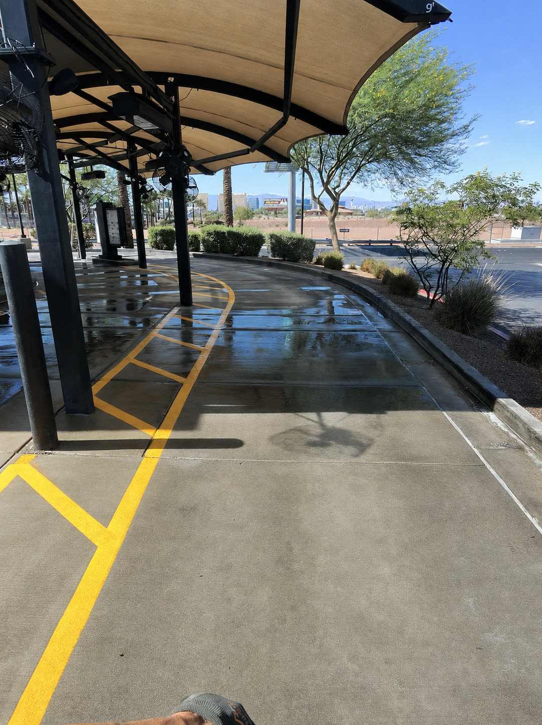 Freshly pressure-washed commercial drive-thru in Las Vegas with the Strip skyline behind